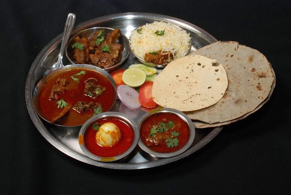 Mutton thali with rassa, egg curry, rice and chapatis